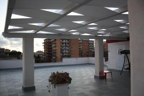 a large room with white ceilings and a balcony with a plant at Guest House Roma Express in Ladispoli