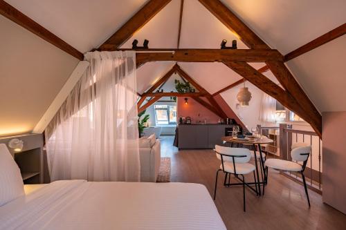 a bedroom with a bed and a table and chairs at The Swiete Den Haag - 2 Stylish boutique apartments - Between city center and the beach in The Hague