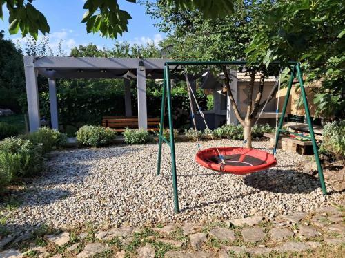 a swing set in a garden with a bench at Holiday House Tone, Imotski-Drum-Makarska in Drum