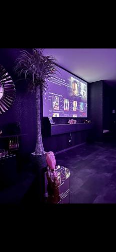 a room with a palm tree and a tv at Love Room Secret-private jacuzzi spa & cinéma Bucuresti in Voluntari