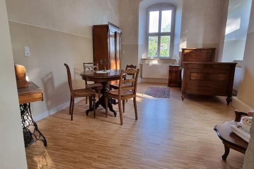 a dining room with a table and chairs and a window at Schloss Kirchschönbach bei Prichsenstadt in Prichsenstadt