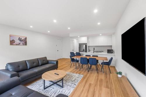 a living room with a couch and a table at "Elegant Home in Highton near City City" in Geelong