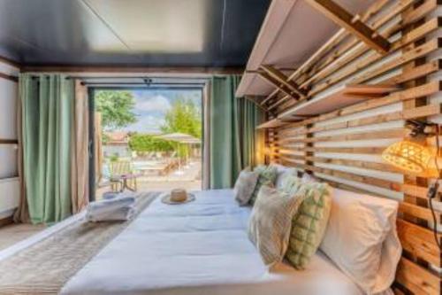 a bedroom with a large bed and a large window at Hôtel Le Grain de Sable in Arès