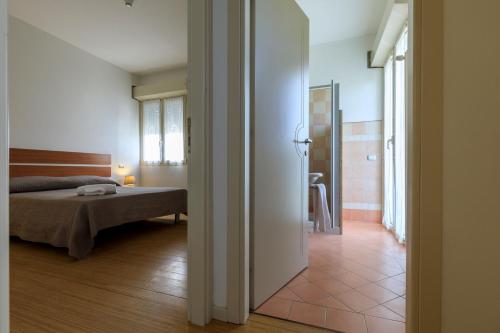 a bedroom with a bed and a room with a bathroom at Residence Rivaverde in Marina di Ravenna