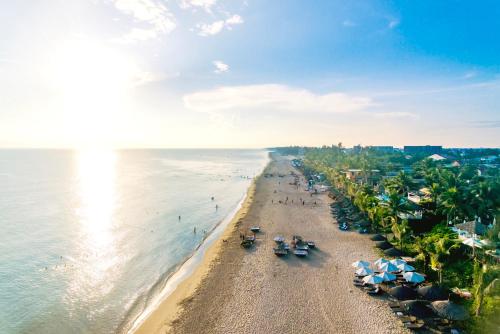 an aerial view of a beach with umbrellas and the ocean at Beach Palm Villa Hoi An in Hoi An