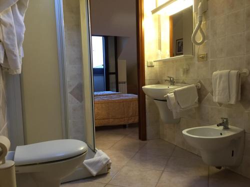 a bathroom with a toilet and a sink and a shower at Hotel Rocco in Carugate