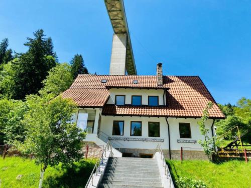 a house with a windmill in the background at Cabana din munte in Moroeni