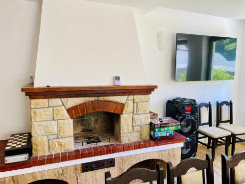 a stone fireplace in a room with chairs and a mirror at Cabana din munte in Moroeni