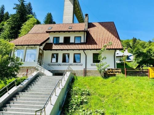 a house on a hill with stairs in front at Cabana din munte in Moroeni