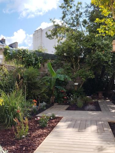 un jardin avec un chemin en bois et des plantes dans l'établissement Les Appartements du 31 - Centre Ville - 2è étage - 50 m2, à Quimper