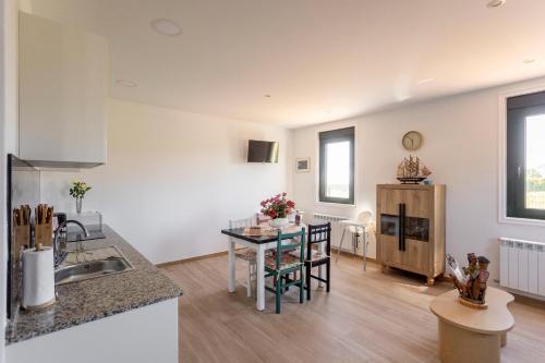 a kitchen and living room with a table and chairs at Apartamentos A Chousa in Valdoviño