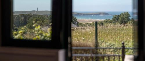 a window with a view of the ocean and a fence at Apartamentos A Chousa in Valdoviño