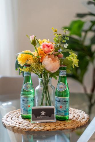 three bottles of beer sitting on a table with flowers at RR - Studio Apartment 38 qm - Parking - Washer in Magdeburg