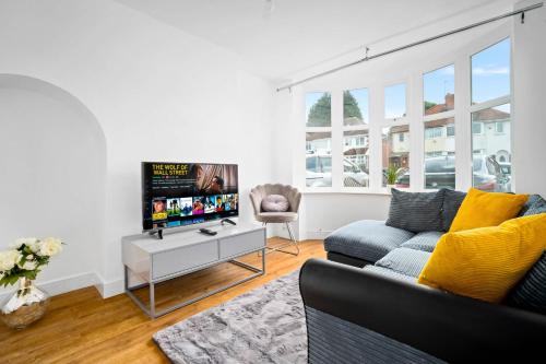 a living room with a couch and a tv at The Rock, Elegant 4 Bedroom House, Solihull, close to NEC, sleeps 8 in Birmingham