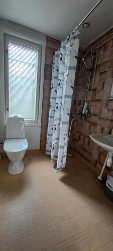 Un baño con inodoro y cortina de ducha. en Toimisto-Majoitus A, en Kokkola