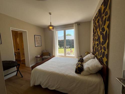 une chambre avec un lit et une grande fenêtre dans l'établissement L authentique, à Agon-Coutainville