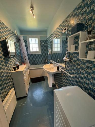 une salle de bain avec un lavabo, des toilettes et une baignoire dans l'établissement L authentique, à Agon-Coutainville