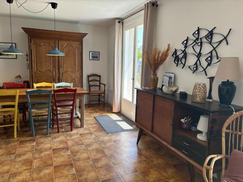 une cuisine et une salle à manger avec une table et des chaises dans l'établissement L authentique, à Agon-Coutainville