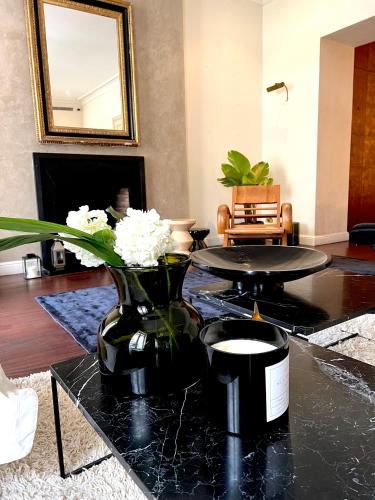 un salon avec une table avec un vase de fleurs dans l'établissement Appartement d'exception Croisette Palais, à Cannes