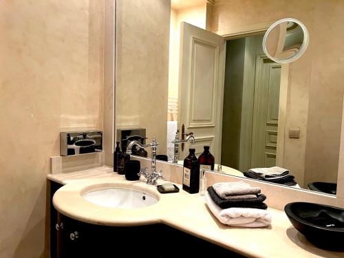 une salle de bain avec un lavabo et un miroir dans l'établissement Appartement d'exception Croisette Palais, à Cannes