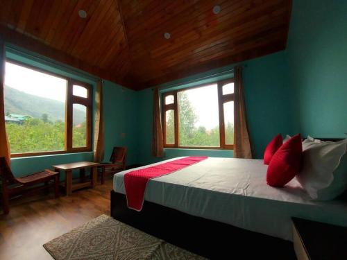 a bedroom with a bed in a room with windows at BnBBuddy Himalayan 3BR Farmstay wid Lawn Near Manali in Manāli