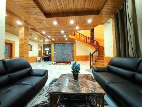 a living room with a couch and a table at BnBBuddy Himalayan 3BR Farmstay wid Lawn Near Manali in Manāli