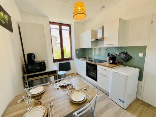 a kitchen with a table and chairs and a kitchen with white appliances at Le République 2, Gare, Centre-Ville in Bourgoin