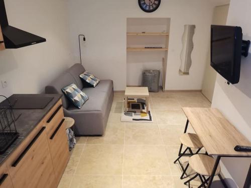 un salon avec un canapé et une table dans l'établissement Studio confort, à Saint-Ambroix