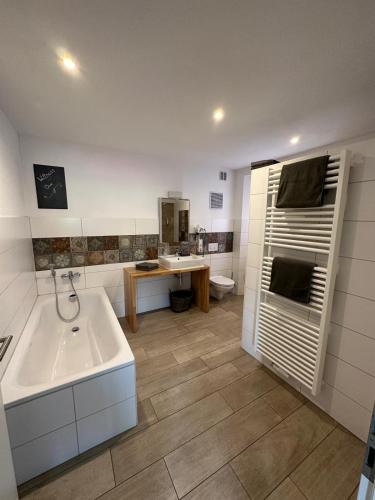 a bathroom with a white tub and a sink at Apartments am Moselufer in Bruttig-Fankel