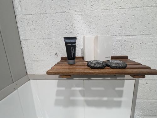 a wooden shelf with a cup and two oreos at Kyabram Country Motel in Kyabram