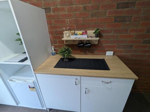 a kitchen with a counter with a brick wall at Kyabram Country Motel in Kyabram