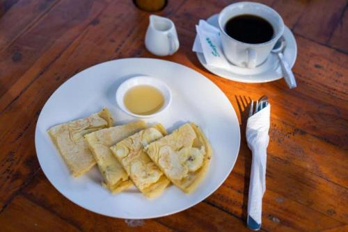 a plate of food on a table with a cup of coffee at Sundi Villa Penida by ABM in Nusa Penida