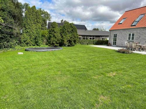a large yard with a trampoline in the grass at Helt nyt hus i idyllisk landsby in Vallensbæk