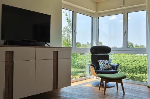 a living room with a chair and a flat screen tv at Bregenz in Bettnau