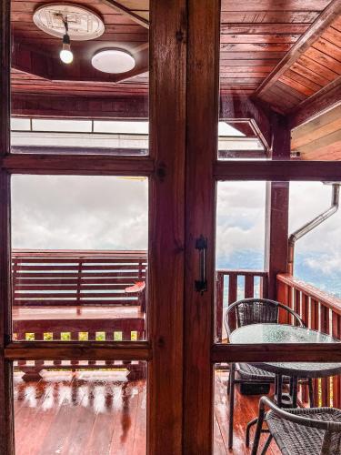 a view from a window of a table and chairs on a balcony at เมฆสวรรค์ ภูทับเบิก in Ban Maeo Thap Boek