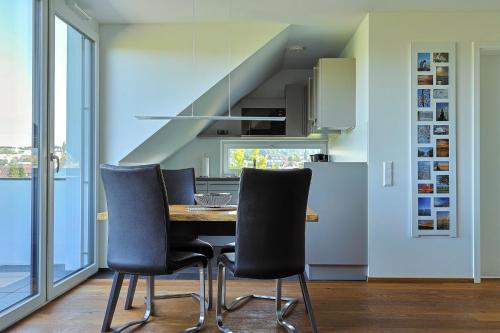 a dining room with a table and three chairs at Säntis in Bettnau