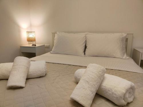 a large white bed with white pillows on it at Luxury Living Peramos in Néa Péramos