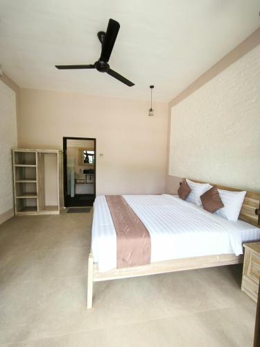 a bedroom with a large bed with a ceiling fan at Stay Together in Tetebatu