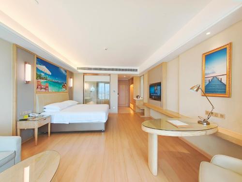a large hotel room with a bed and a table at Vienna International Hotel Wenchang in Wenchang