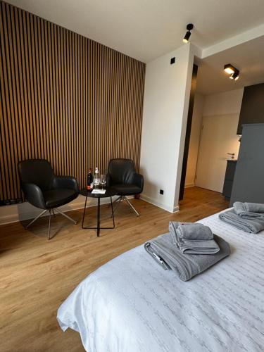 a room with two beds and two chairs and a table at Garden Apartments in Berlin