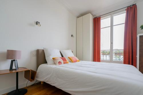 une chambre avec un grand lit blanc avec une fenêtre dans l'établissement Luxury and Comfort in the Heart of Paris, à Paris