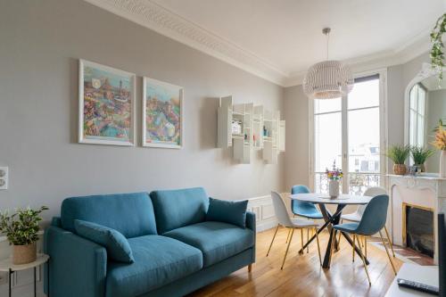 un salon avec un canapé bleu et une table dans l'établissement Luxury and Comfort in the Heart of Paris, à Paris
