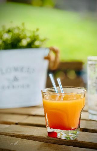 a glass of orange juice sitting on a table at The Green Apartments in Magarevo