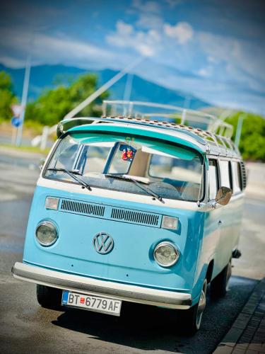 a blue and white van with a surfboard on top at The Green Apartments in Magarevo