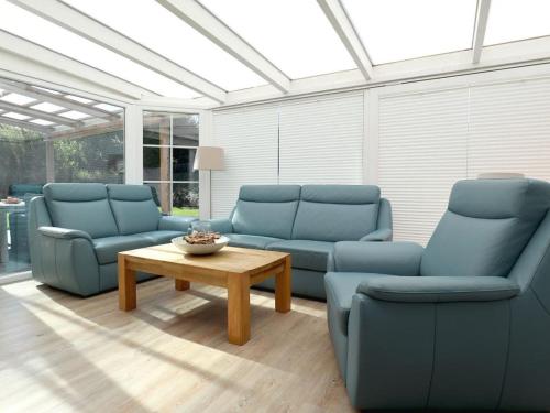 a living room with blue couches and a coffee table at Teresa Fewo in Boltenhagen