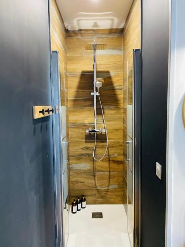La salle de bains est pourvue d'une douche et de murs en bois. dans l'établissement Appartement de standing hyper centre, à Tours