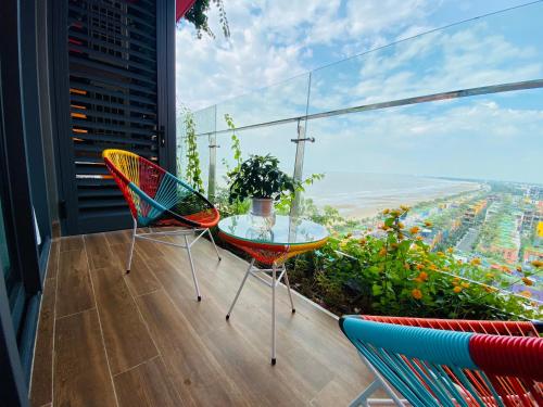 a balcony with two chairs and a glass table at Căn hộ IB1011 Tự Doanh toà 21 tầng Flamingo Hải Tiến in Thanh Hóa