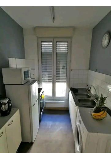 une cuisine avec un évier et une cuisinière four supérieur dans l'établissement appartement cosy porte de Paris, à Montrouge