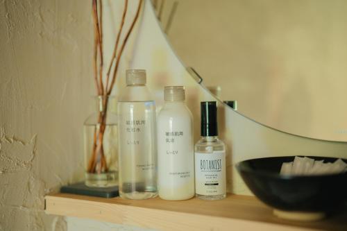 a shelf with two bottles of soap and a bowl at moon hakone in Hakone