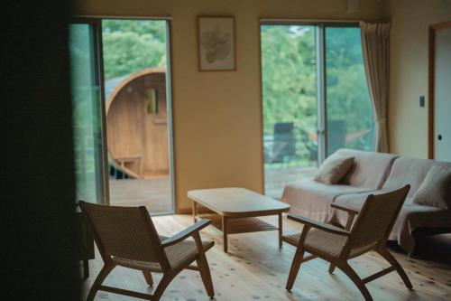 a living room with chairs and a couch and a table at moon hakone in Hakone